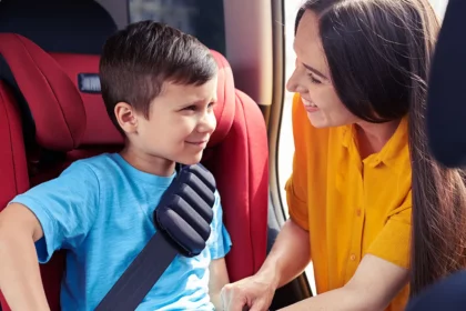 mother-strapping-in-child-in-booster-car-seat