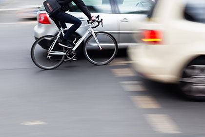 Bicyclist-riding-in-between-cars-in-a-traffic