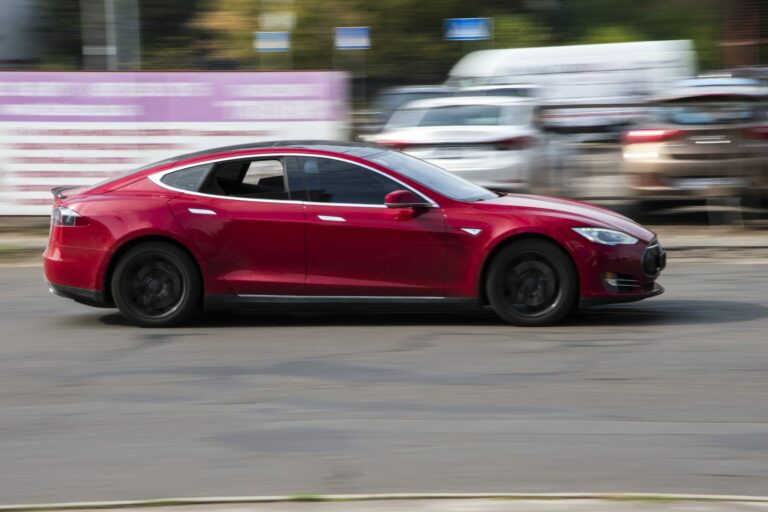 Coche Tesla Model 3 rojo circulando por la calle