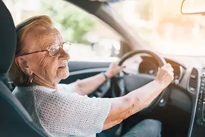 senior driver behind the wheel highlighting safe-driving considerations to prevent injury risks