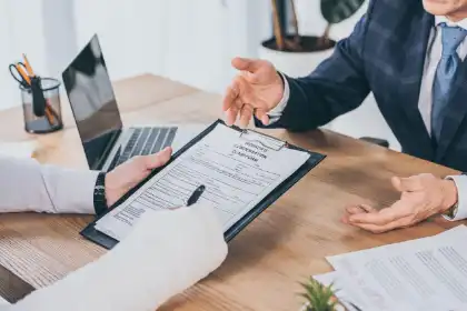 Person signing a document during a meeting with a lawyer