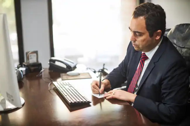 Arash Law lawyer taking notes on a workplace accident case in Oakland