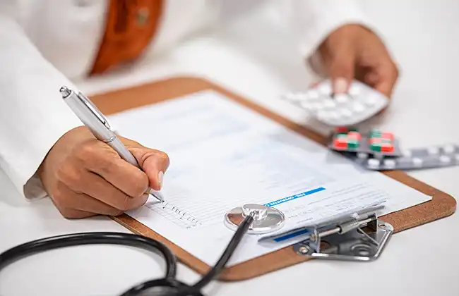 Doctor writing a medical prescription with pills and records, supporting Uber accident claim documentation