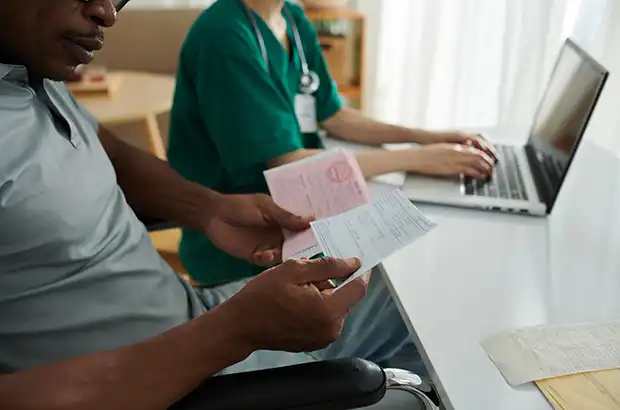 Injured man reviewing medical documents with assistance after car accident