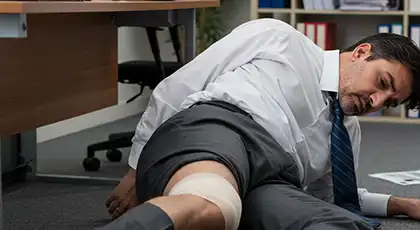 Injured man in office attire lying on floor after workplace accident