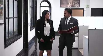 Two Arash Law attorneys walk through office reviewing a case.