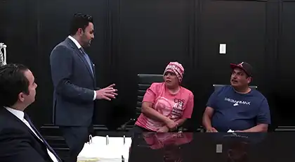 AK Lawyer speaks with two clients during a workers’ compensation consultation in an office