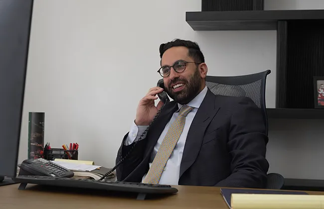 AK lawyer speaking on the phone at his desk in Garden Grove