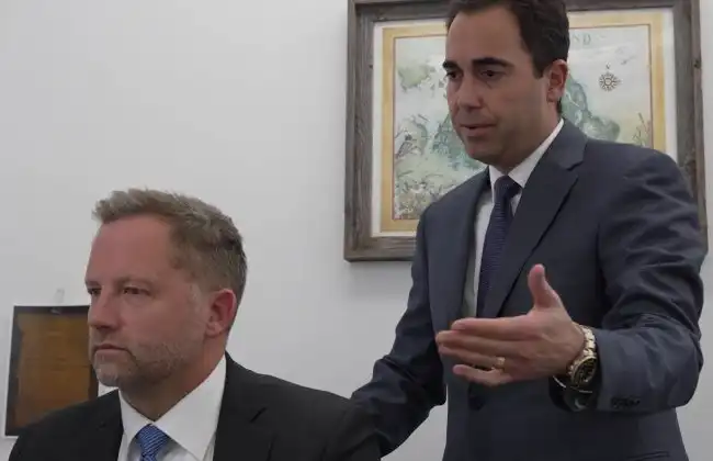 AK lawyer standing and explaining a legal matter to a colleague in an office