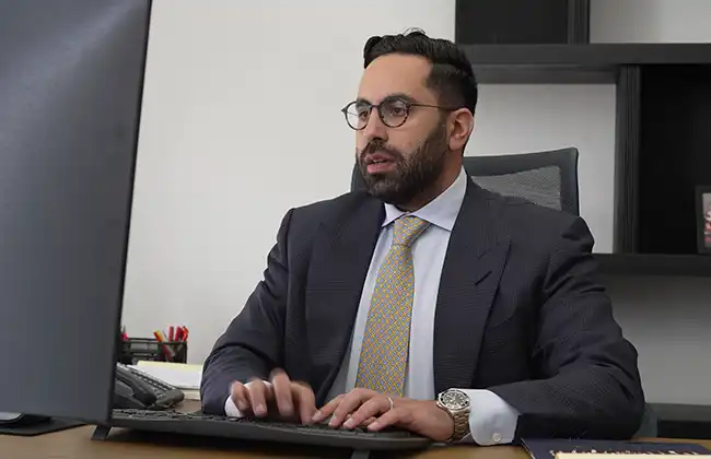 AK lawyer working at a desktop computer handling legal matters