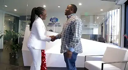 Client shaking hands with an AK lawyer in the Arash Law office lobby during a legal consultation