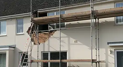 Scaffolding set up on a house exterior lacks proper guardrails, creating a serious fall hazard