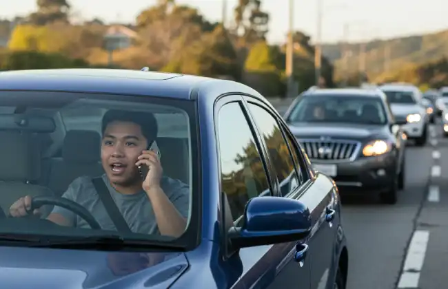 Distracted driver talking on the phone while operating a vehicle in traffic