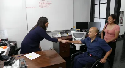 injured man on a wheelchair shaking hands with a lawyer