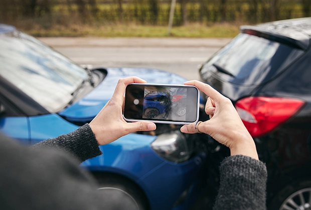 Mujer tomando fotos del accidente por conducir bajo los efectos del alcohol como prueba en Pasadena