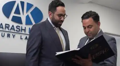 Two AK car accident attorneys reviewing case documents at a law office