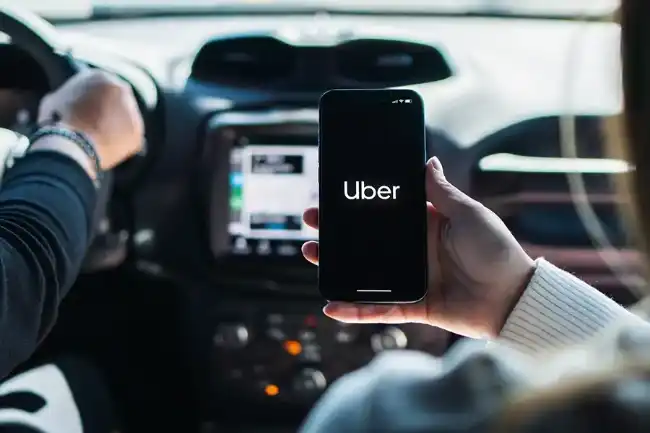 Uber accident passenger holding phone with Uber app