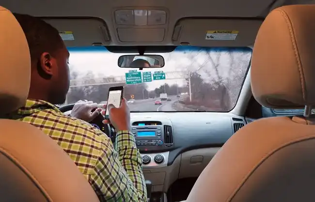 Uber accident risk with driver distracted on his mobile phone while driving
