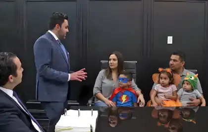 Family with children in Halloween costumes consulting lawyers about accident claims