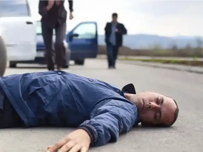 Man with personal injuries lying on the ground after being in an accident