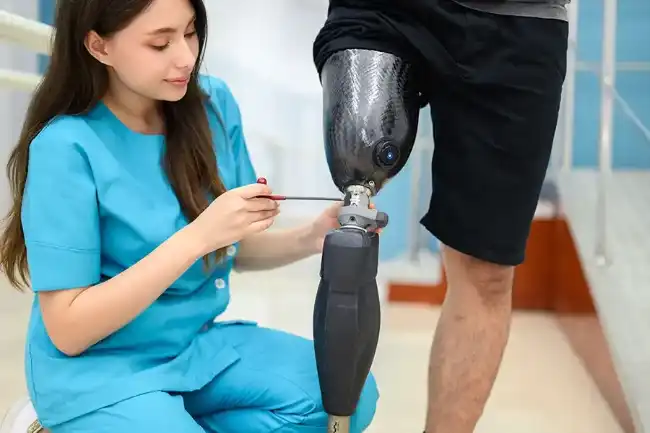 Nurse helping accident victim on his prosthetic leg