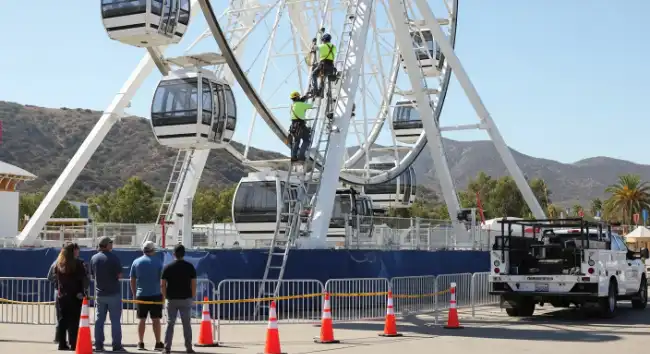 Rescuers going up the stalled ferris wheel