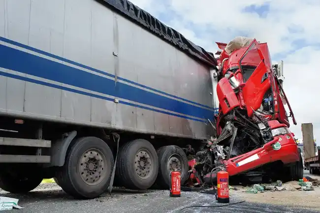 Truck accident aftermath showing severely wrecked front of truck