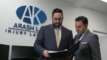 Two personal injury lawyers reviewing case documents at Arash Law office