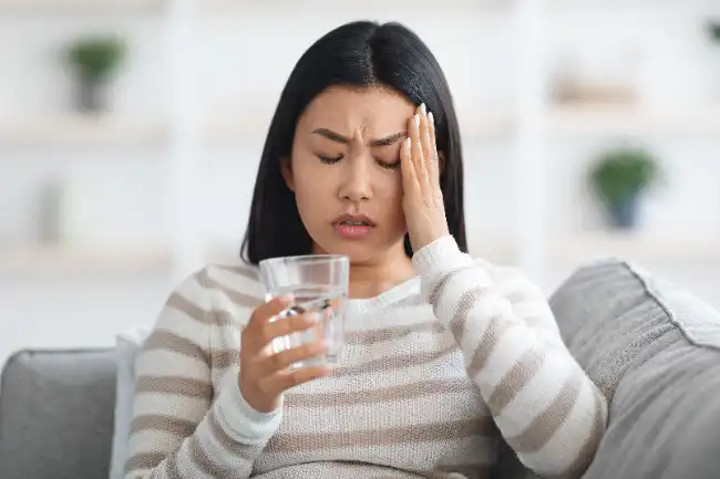 Woman experiencing headache after a head injury