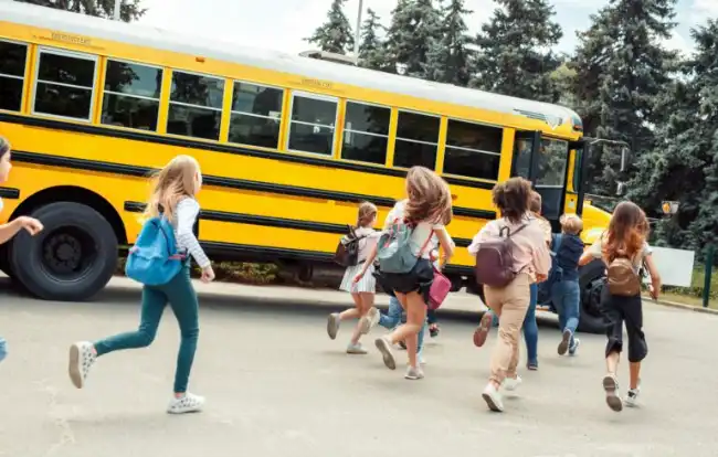 children running to catch the school bus