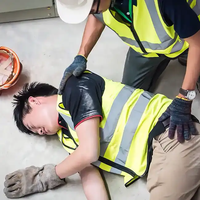 man helping his coworker after a construction accident