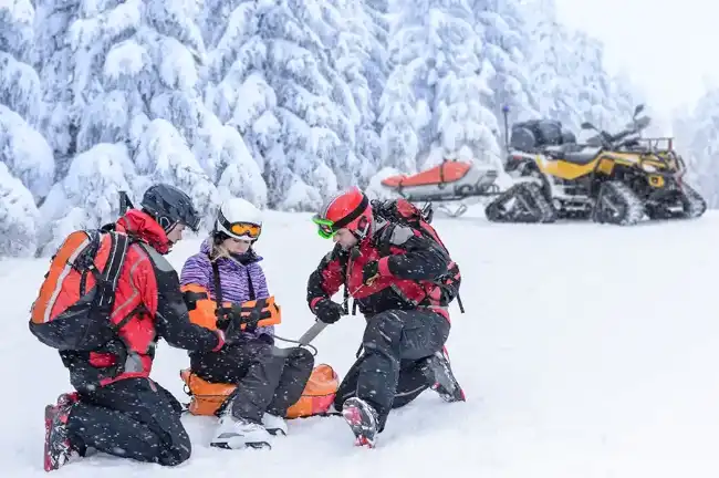 rescuers helping a ski accident victim