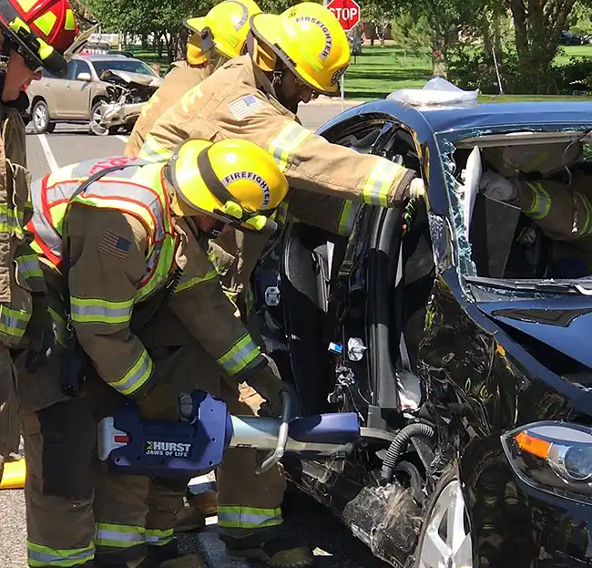 team of firefighters helping an injured victim of a catastrophic car accident