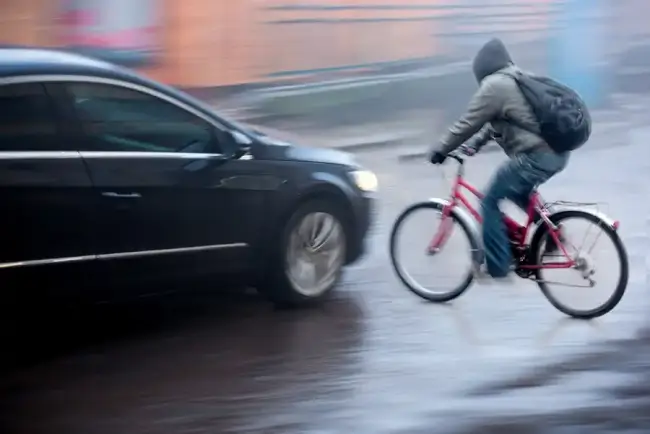 Bicycle accident risk with speeding car about to collide with cyclist