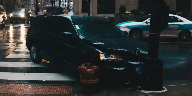 Intersection accident showing a car crashed into a post