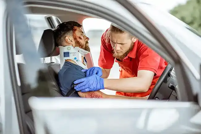 Medical personnel providing help to a man involved in a car accident in Orange County