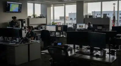 Office workers in a dimly lit federal workplace during reduced operations from a government shutdown
