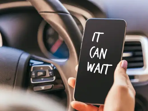 Phone displaying a safety reminder to avoid distracted driving accident risks