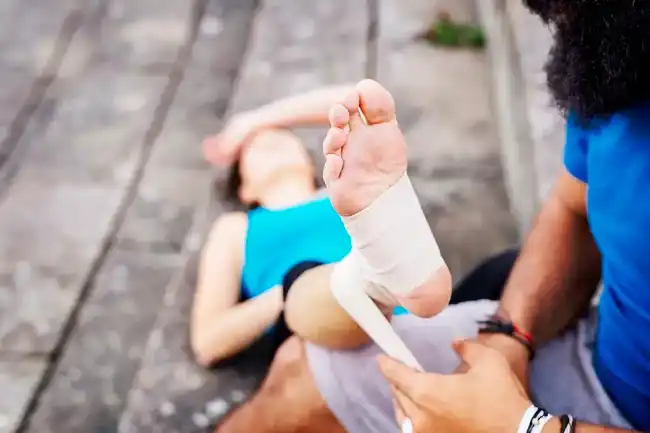Rain accident victim being assisted with her injured feet