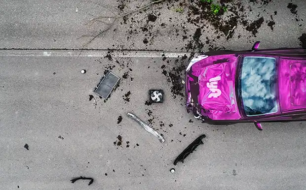 Severe Lyft rideshare crash with debris scattered across the roadway
