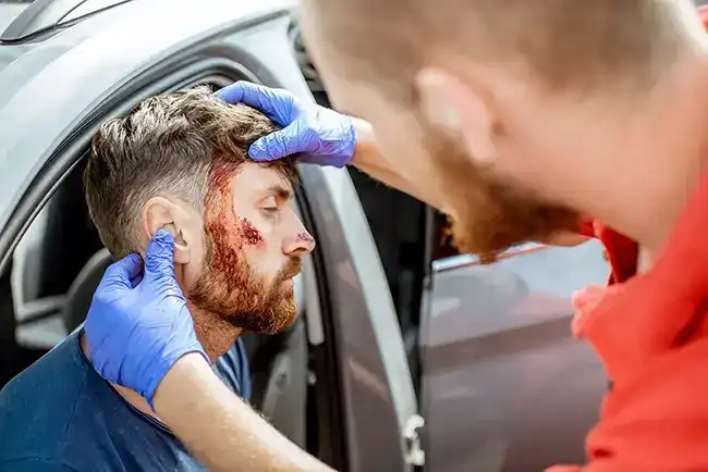Medic checking injured man after being involved in an Uber accident