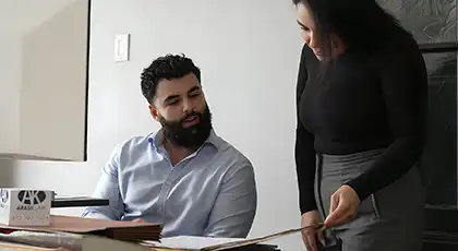 AK Law attorney reviews case documents with a client in office