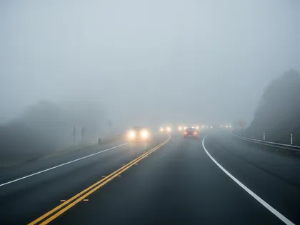 Foggy road conditions with limited visibility and vehicle headlights