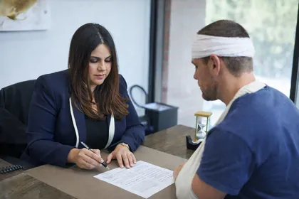 Injured man meeting with a car accident lawyer to discuss an insurance claim and possible legal action