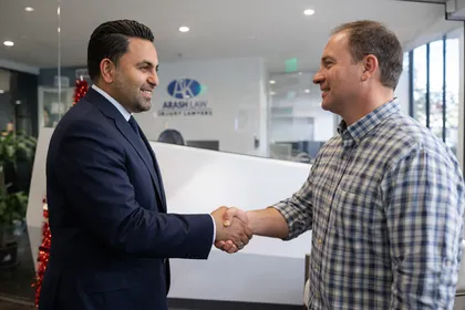Car accident lawyer shaking hands with a client at the law office