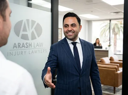 Lawyer welcoming accident victim to Arash Law office for injury claim consultation