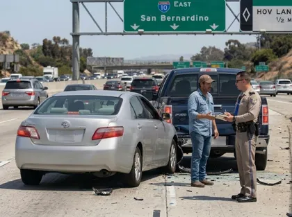 Rear-end accident on busy California interstate with officer documenting damage between Toyota sedan and pickup truck
