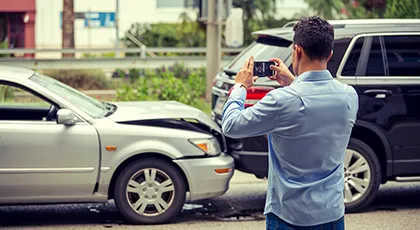 Un hombre que documenta un accidente de tráfico por alcance para el seguro o una reclamación legal