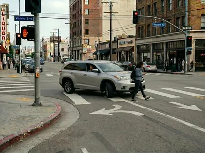 A speeding car approaching woman at pedestrian crosswalk