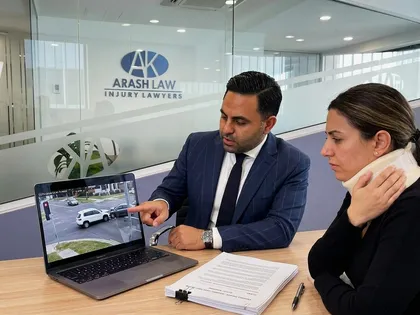 Abogado explicando a la víctima la reclamación por accidente con las imágenes de las cámaras de seguridad en la pantalla
